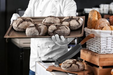 Erkek baker tepsi taze ekmek ile dükkanda holding
