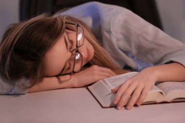 Akşam masada yatıyor kitapla genç kadın