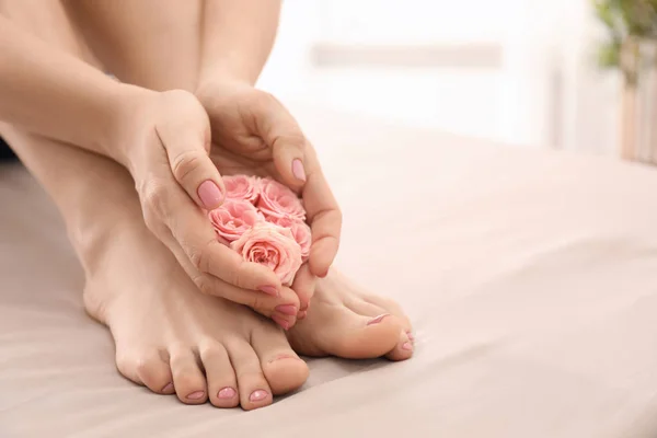 Young woman with beautiful pedicure and manicure after treatment in spa salon