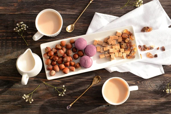 Composition of cups of tea with milk on wooden background, top view