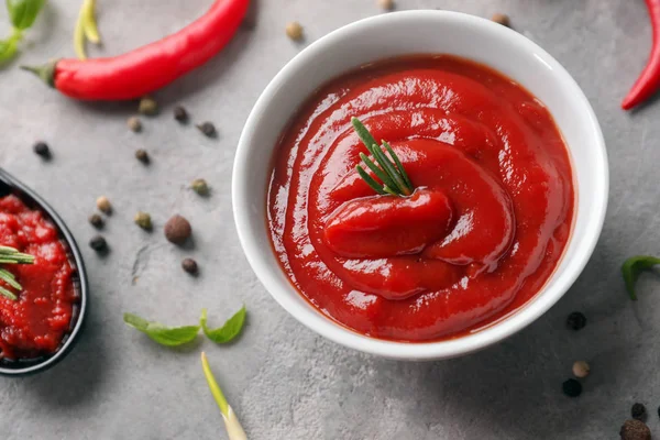 Schüssel Mit Köstlicher Tomatensauce Mit Gewürzen Auf Grauem Tisch — Stockfoto