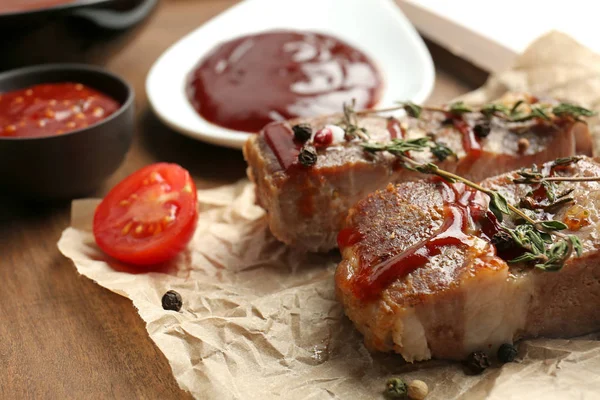 Delicious grilled meat with barbecue sauce on wooden board, closeup