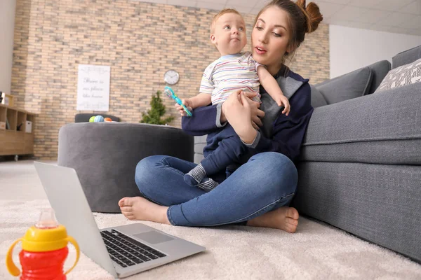 Ung Mamma Innehav Baby Medan Arbetar Hemma — Stockfoto
