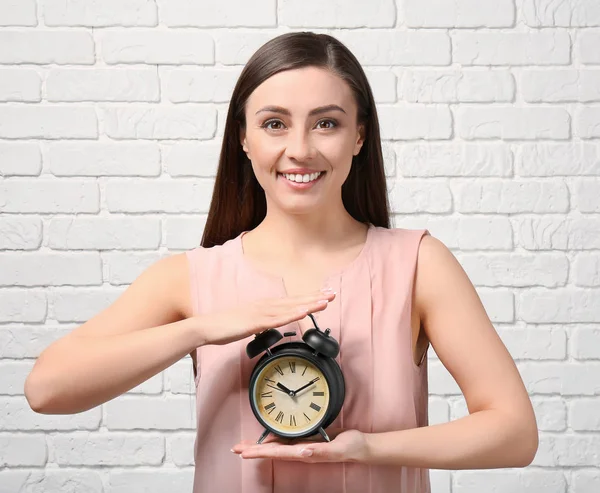 Frau Mit Wecker Gegen Weiße Backsteinmauer Zeitmanagement Konzept — Stockfoto