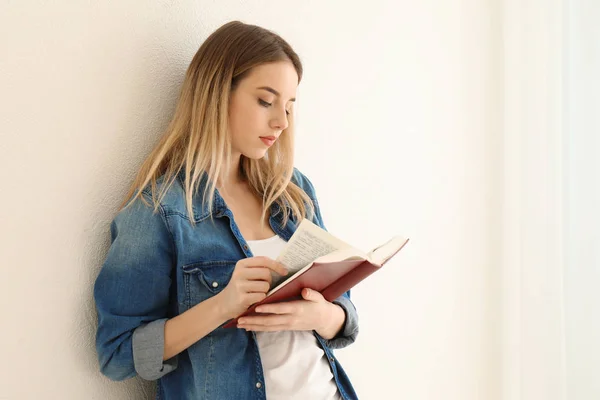 Joven Mujer Leyendo Libro Cerca Pared Luz —  Fotos de Stock