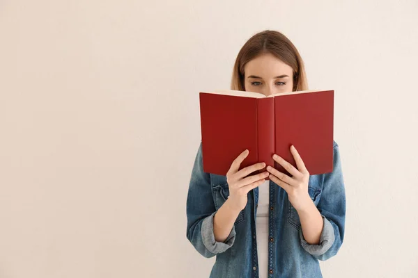 Jonge Vrouw Lezen Boek Buurt Van Lichte Muur — Stockfoto