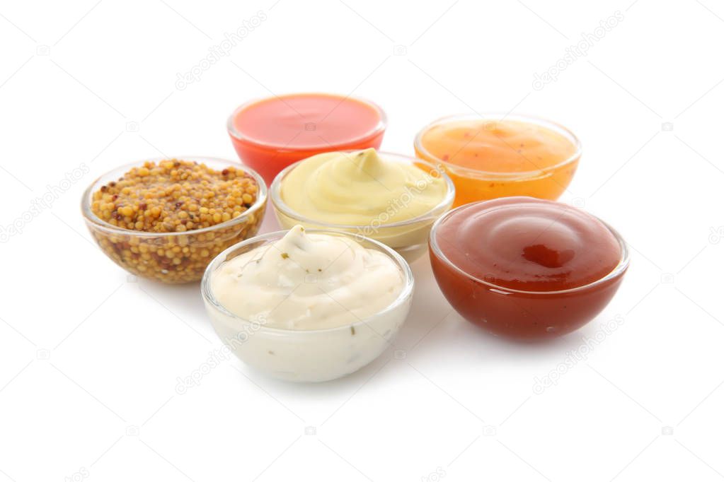 Bowls with different sauces on white background