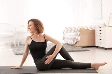 Güzel kadın sabah evde yoga uygulamak