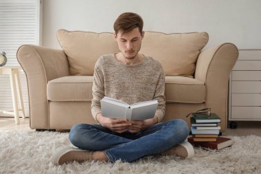 Genç adam evde kitap okuma