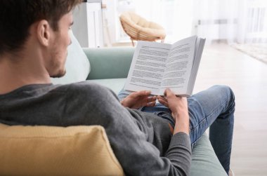 Evde istirahat ederken okuma kitabı genç adam