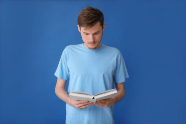 Genç adam renk arkaplanı kitabı okuyor