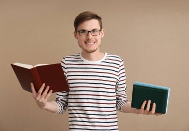 Renkli arka plan kitapları olan genç bir adam.