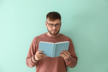 Genç adam renk arkaplanı kitabı okuyor
