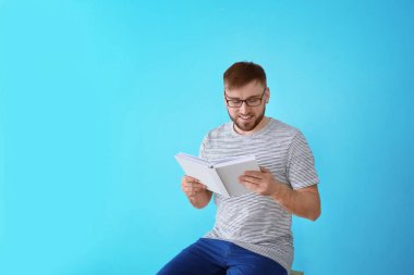 Genç adam renk arkaplanı kitabı okuyor