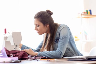 Genç kadın terzi dikiş makinesi atelier içinde kullanma