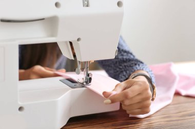 Genç kadın terzi dikiş makinesi, closeup kullanarak