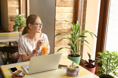 Kafede çalışan dizüstü bilgisayar ile genç serbest meslek