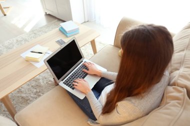 Evde dizüstü bilgisayarda çalışan serbest çalışan bir kadın.