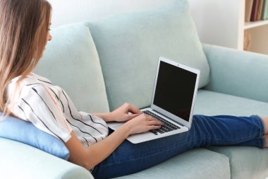 Evde dizüstü bilgisayarda çalışan serbest çalışan bir kadın.