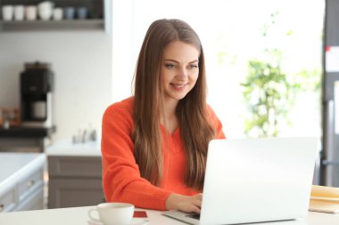 Evde dizüstü bilgisayarda çalışan serbest çalışan bir kadın.