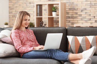 Evde dizüstü bilgisayarda çalışan serbest çalışan bir kadın.