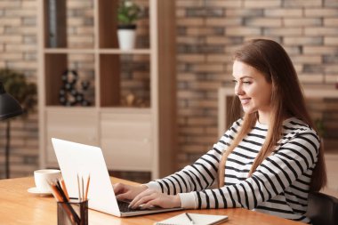 Ev ofis içinde laptop üzerinde çalışan kadın serbest meslek