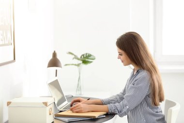Ev ofis içinde laptop üzerinde çalışan kadın serbest meslek