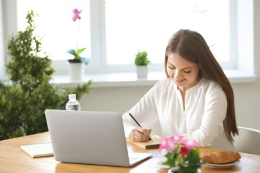 Ev ofis içinde laptop üzerinde çalışan kadın serbest meslek