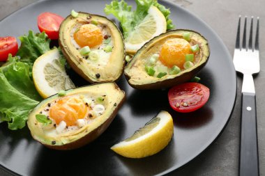 Plaka, closeup üzerinde avokado ve taze sebze pişmiş yumurta