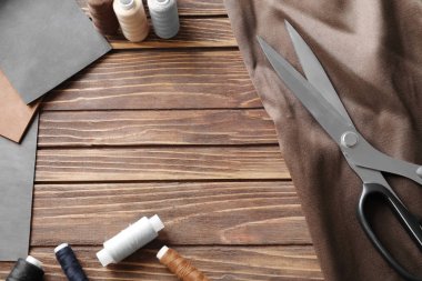 Kumaş ve dikiş ipliği ahşap arka plan üzerinde örnekleri