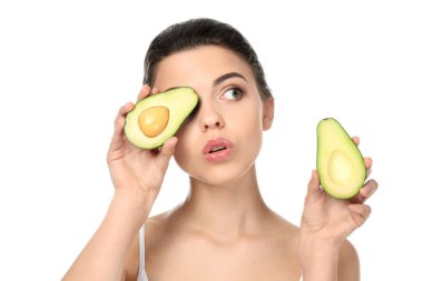 Beyaz arka planda avokadosu olan güzel genç bir kadın.