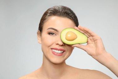 Avokado ışık arka plan üzerinde olan güzel kadın