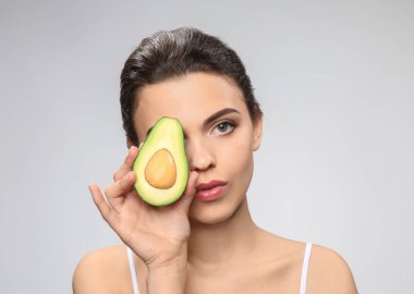 Avokado ışık arka plan üzerinde olan güzel kadın