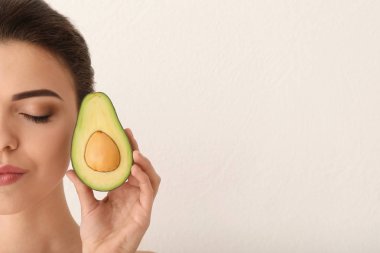 Avokado ışık arka plan üzerinde olan güzel kadın