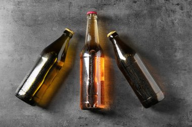 Taze bira gri arka plan üzerinde cam şişelerde