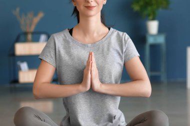 Evde yoga yapan genç bir kadın.