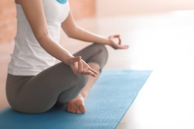 Evde yoga yapan genç bir kadın.