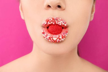 Yaratıcı makyaj ve renk arka plan, closeup Ağızdan şeker olan güzel kadın