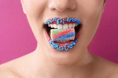 Yaratıcı makyaj ve renk arka plan, closeup Ağızdan şeker olan güzel kadın