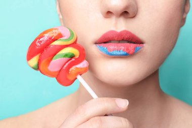Yaratıcı makyaj ve lolipop renk arka plan, closeup üzerinde olan güzel kadın