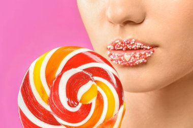 Yaratıcı makyaj ve lolipop renk arka plan, closeup üzerinde olan güzel kadın