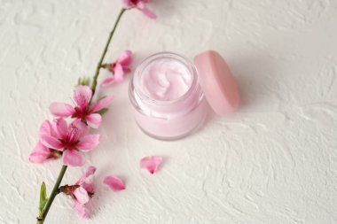 Kavanoz krem ve masada çiçek şube