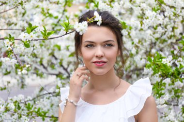 Bahar gününde çiçek açması tree yakınındaki güzel genç kadın