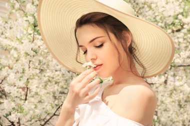 Bahar gününde çiçek açması tree yakınındaki güzel genç kadın