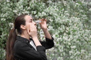 Göz kullanan genç kadın çiçek açan ağacın yanında bırakır. Anti kavramı