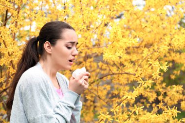 Çiçeklenme tree yakınındaki burun silecek olan kadın. Anti kavramı