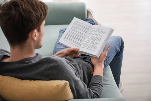 Молодой Человек Читает Книгу Отдыхая Дома — стоковое фото