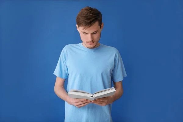 Junger Mann Liest Buch Auf Farbigem Hintergrund — Stockfoto