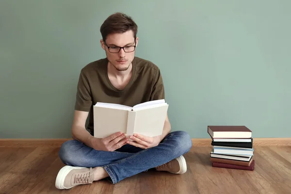 Joven Leyendo Libros Mientras Está Sentado Suelo Cerca Pared Color — Foto de Stock