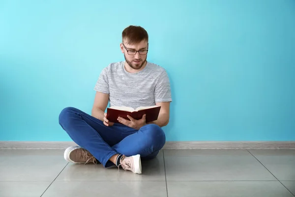 Young Man Reading Book While Sitting Color Wall — Stock Photo, Image